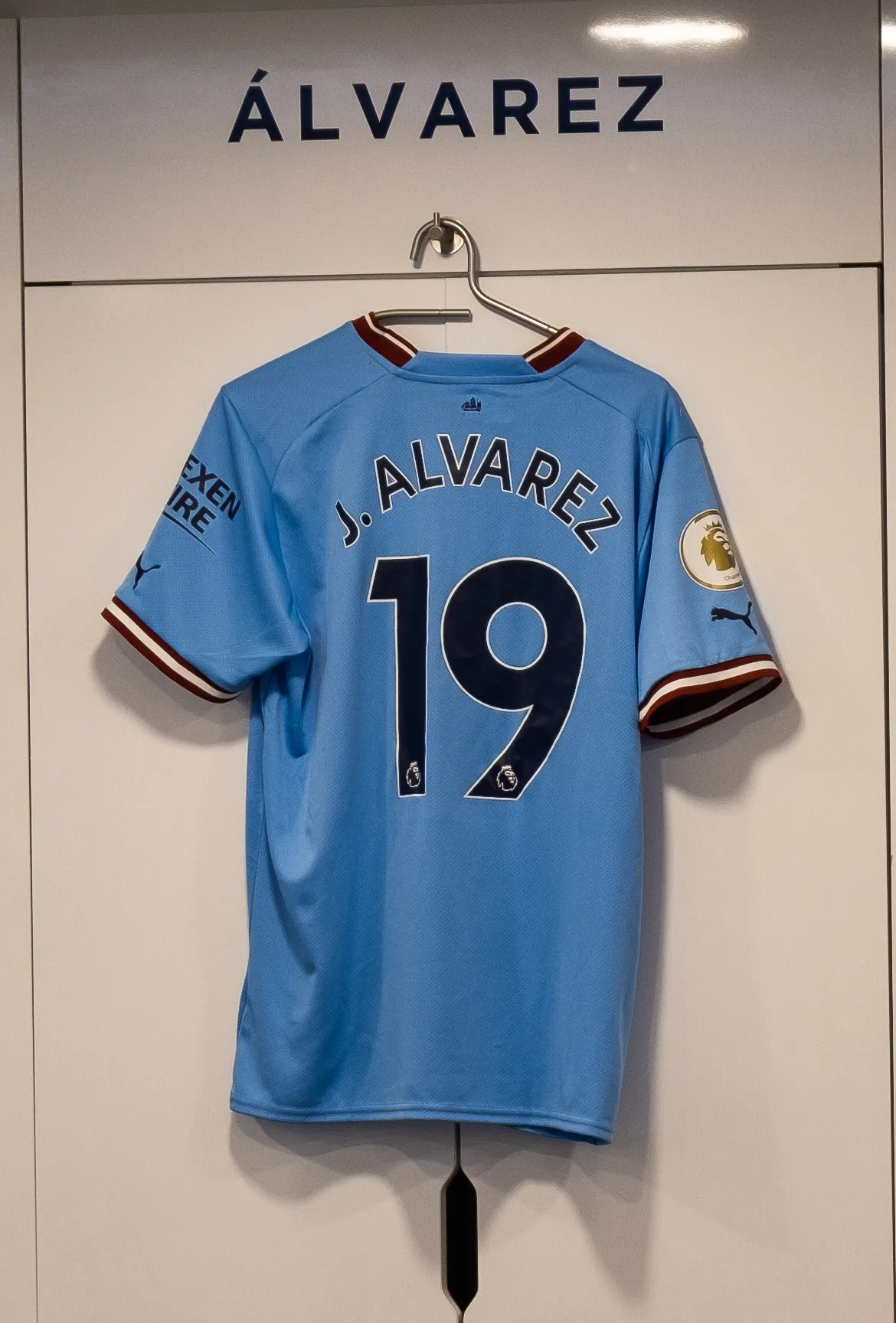 Real close-up of a Manchester City shirt displayed in the home dressing room